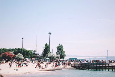 People in beach against clear sky