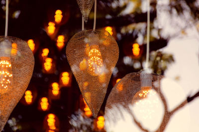 Close-up of illuminated lighting equipment hanging at night