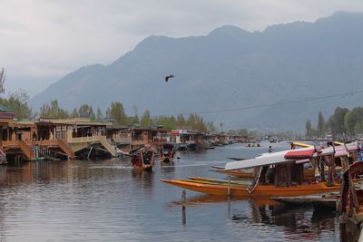 Boats moored in river with buildings in background