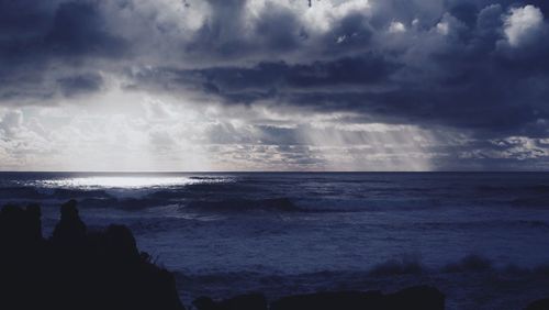 Scenic view of sea against storm clouds