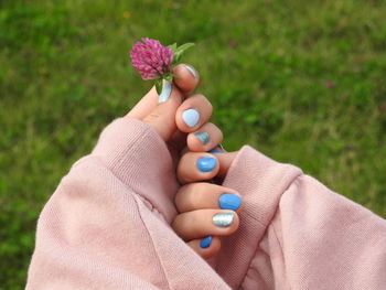 Close-up of hand holding purple flower