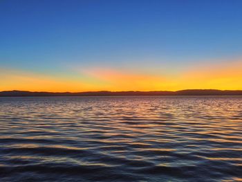 Scenic view of sea against clear sky during sunset