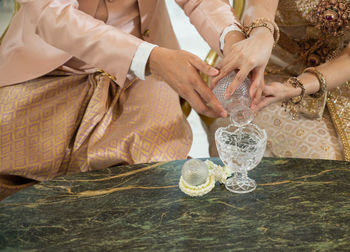 Midsection of bride holding wedding dress