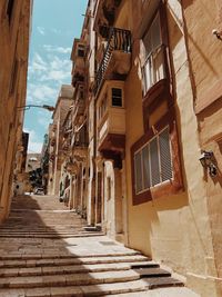 Low angle view of alley amidst buildings in city