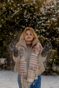 Portrait of young woman standing on snow