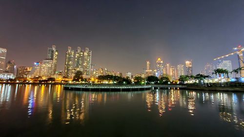 Illuminated buildings in city against sky at night