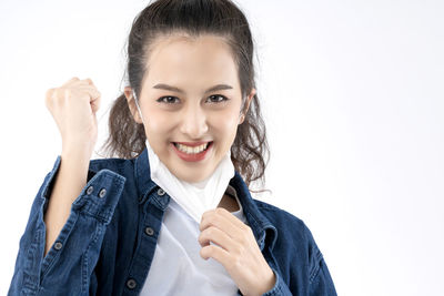 Portrait of smiling young woman against white background