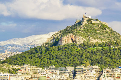 Panoramic view of townscape and mountains against sky