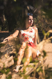 Portrait of young woman sitting on field