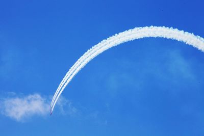 Low angle view of airplane flying against clear blue sky