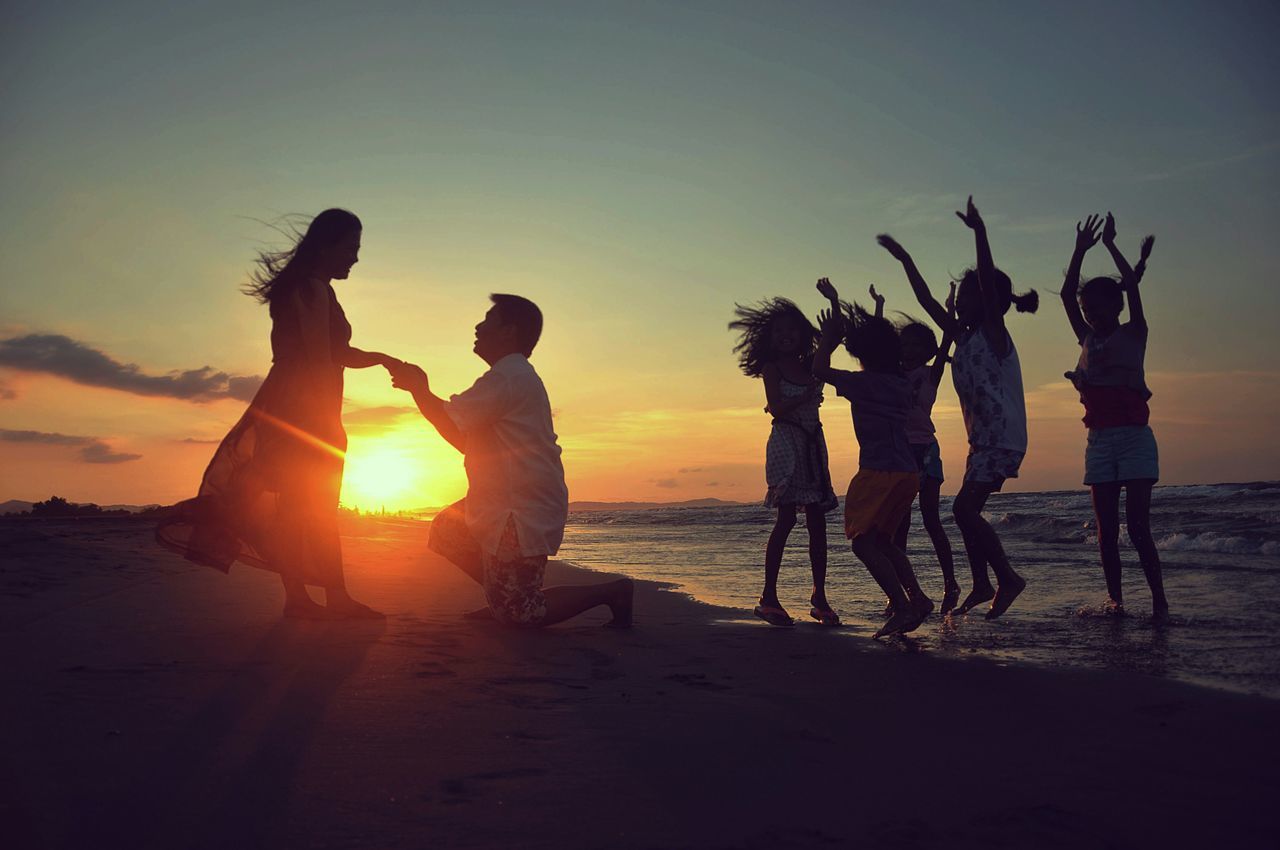 sunset, beach, sea, sun, shore, water, silhouette, leisure activity, lifestyles, sand, horizon over water, men, orange color, togetherness, vacations, enjoyment, sky, scenics, large group of people