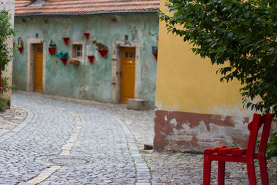 Empty street amidst houses against buildings