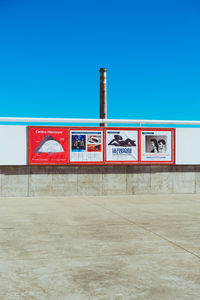 Information sign against clear blue sky