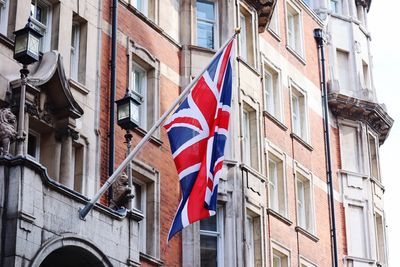 Low angle view of flag against buildings in city