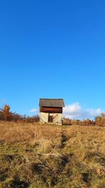 Built structure on field against clear blue sky