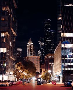 Illuminated buildings in city against sky at night