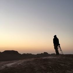 Silhouette man standing on mountain against clear sky