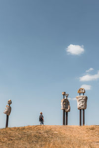 Rear view of man standing on field against sky