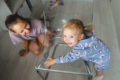 High angle view of mother and daughter playing at home