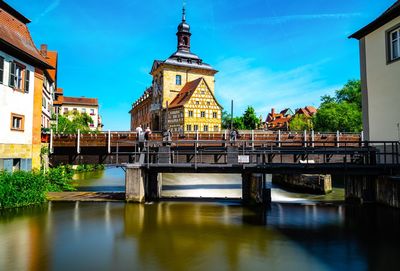 Bridge over river amidst buildings against sky