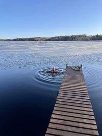 Pier over lake against clear sky