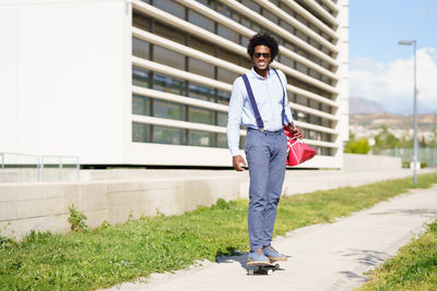 Portrait of young man standing against built structure