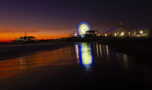 Illuminated ferris wheel by on santa monica pier