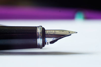 Close-up of pen on book against white background