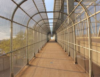 Corridor in greenhouse against sky