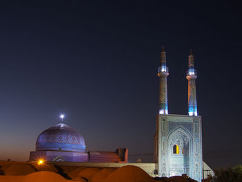 Low angle view of illuminated buildings against sky at night