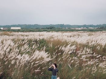 Woman standing amidst plants on landscape