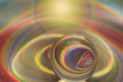 Reflection of geometric and abstract pattern in glass sphere with rainbow colors effect.