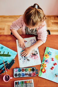 High angle view of girl drawing on paper at home