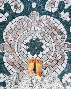 Low section of person standing on tiled floor