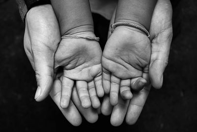 Close-up of father holding child hand