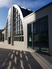 Office building against sky on sunny day