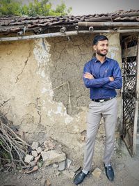 Portrait of young man standing against wall