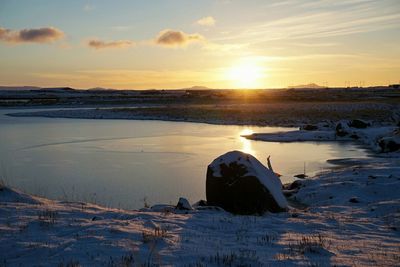 Scenic view of snow covered landscape at sunset