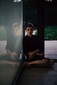 Portrait of woman sitting by window at home