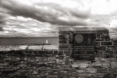 Built structure by sea against sky