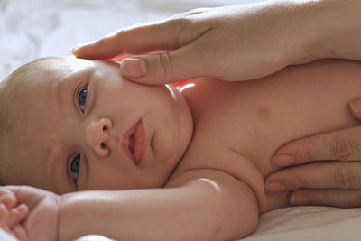 Mother giving massage to little child infant.  female hands massaging to newborn.  cream, body care