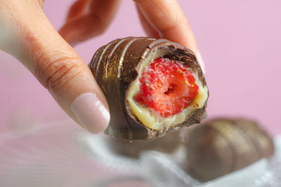 Close-up of hand holding strawberry chocolate