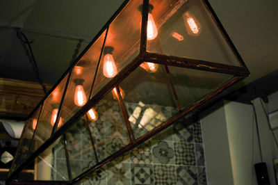 Low angle view of illuminated lights hanging on ceiling in building