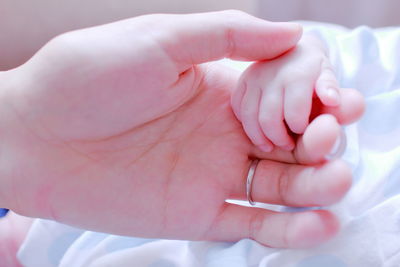 Extreme close up of hand holding baby hand