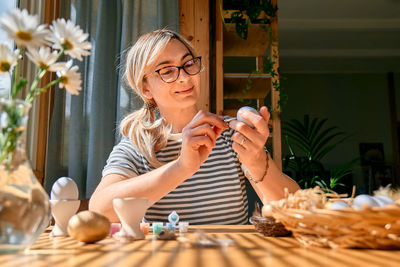 Portrait of young woman using mobile phone at home