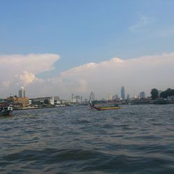 Boats in river with city in background