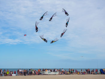 Group of people flying against sky