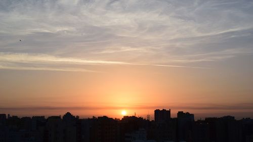 High angle view of silhouette buildings against sky during sunset