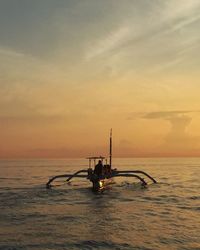 Silhouette boat in sea against sky during sunset