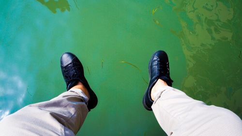 Low section of man standing by water